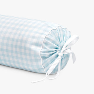 Blue checkered bolster pillow with a white ribbon on a light gray background