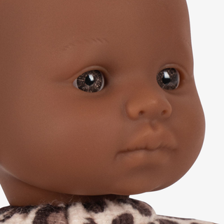 Close-up of a doll with brown skin and dark eyes on a white background