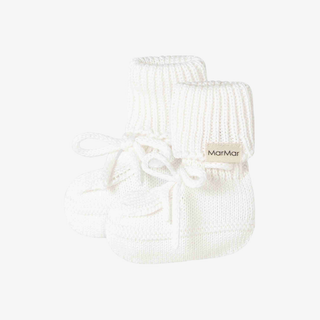 A pair of white knit baby booties with white laces and a small beige brand tag reading 'MarMar'
