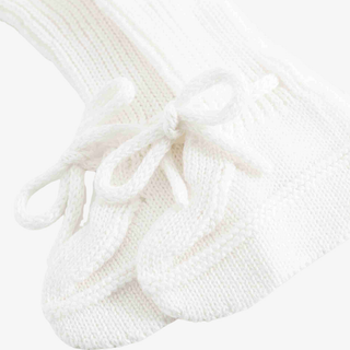 A close-up of a white ribbed knit sock with a matching knitted bow detail on the side, shown against a plain light background.