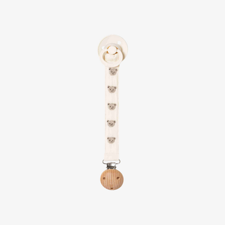 A white pacifier clip with a natural wood ball charm and small bear face details, shown against a plain light gray background.