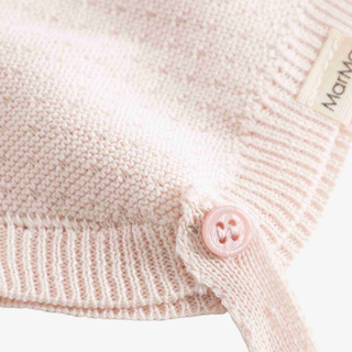 bonnet pale pink knit garment with a matching pink button 