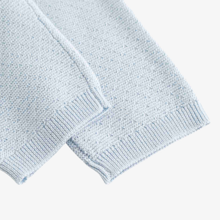 Close-up of a light blue knit baby pants with ribbed cuffs, showing the texture and stitching detail against a plain white background.