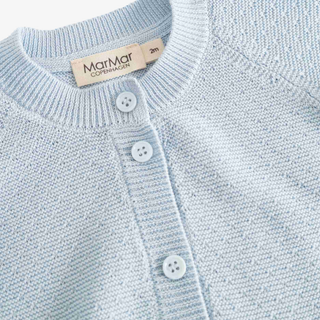 Close-up of a light blue knit cardigan sweater with a round neck, three white buttons, and a visible MarMar Copenhagen brand label.