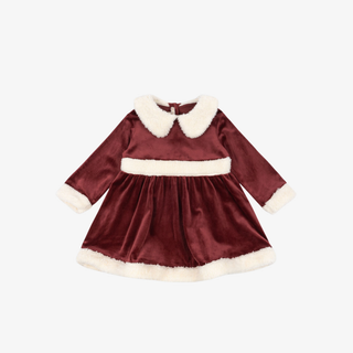 Red velvet dress with white trim on a white background
