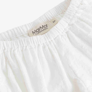 Close-up of a white textured cotton garment with an elastic waistband, showing a beige MarMar Copenhagen brand label.