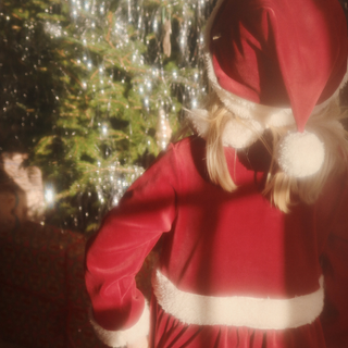 Person wearing a red Santa Claus outfit with white trim in a snowy outdoor setting.