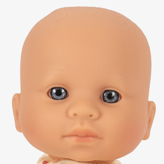 Close-up of a realistic baby doll head with smooth peach skin, large dark eyes, and a neutral expression on a light gray background.