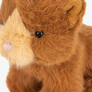 Close-up of a plush stuffed animal with medium brown fur, a little pink nose, and black bead eyes, on a white background.