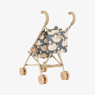 A stroller with a swan-patterned fabric seat cover and matching bag, featuring a beige frame and curved handles, shown against a plain light gray background.