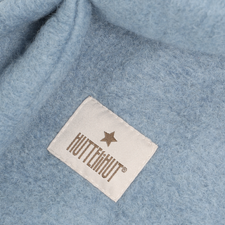 A close-up of light blue fuzzy fabric with a sewn-on brand label.
