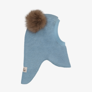 A blue child's balaclava with two fluffy pom-poms on the top, shown against a plain light gray background.