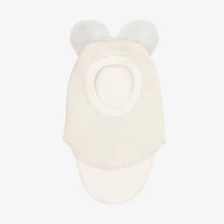 A cream-colored child's balaclava with two fluffy pom-poms on the top, shown against a plain light gray background.