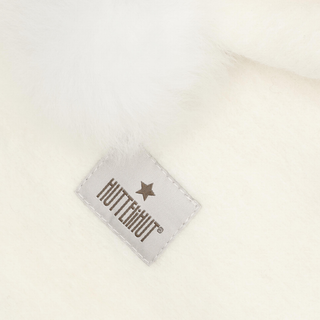 Close-up of a white faux fur material with a small sewn label.