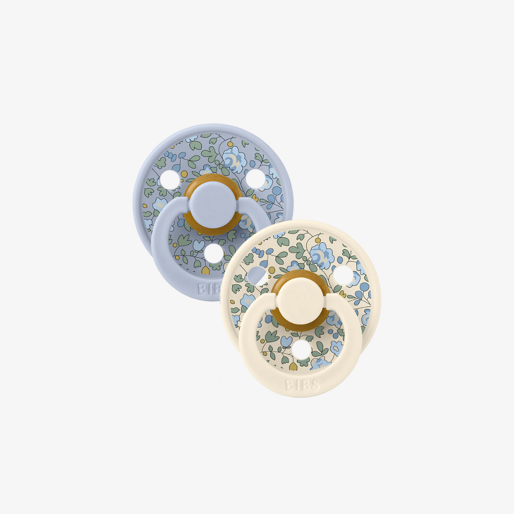 Two floral-patterned baby soothers on a white background