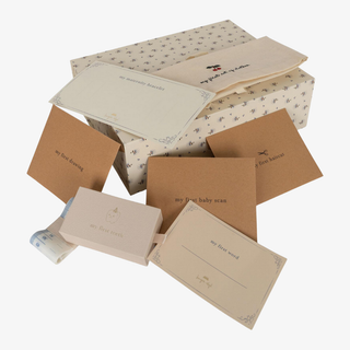 Collection of baby keepsake boxes and cards on a white background