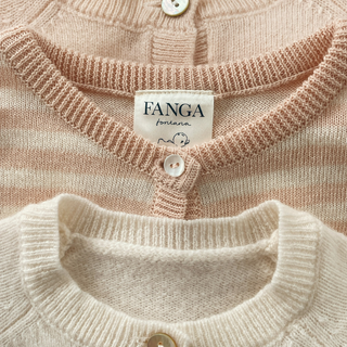 Close-up of a pink and beige knitted cardigan with 'FANGA' label.