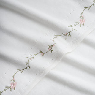 Closeup of Knit Baby Blanket with Vine and Floral embroidered details. 