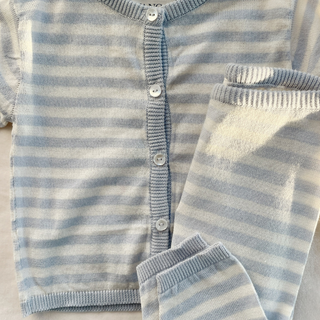 Close-up of a baby outfit with blue and white stripes on a neutral background