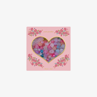 Heart-shaped box with colorful beads and floral design on a pink background