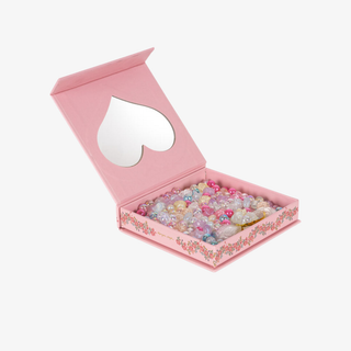 Pink jewelry box with heart-shaped mirror and colorful beads inside on a white background