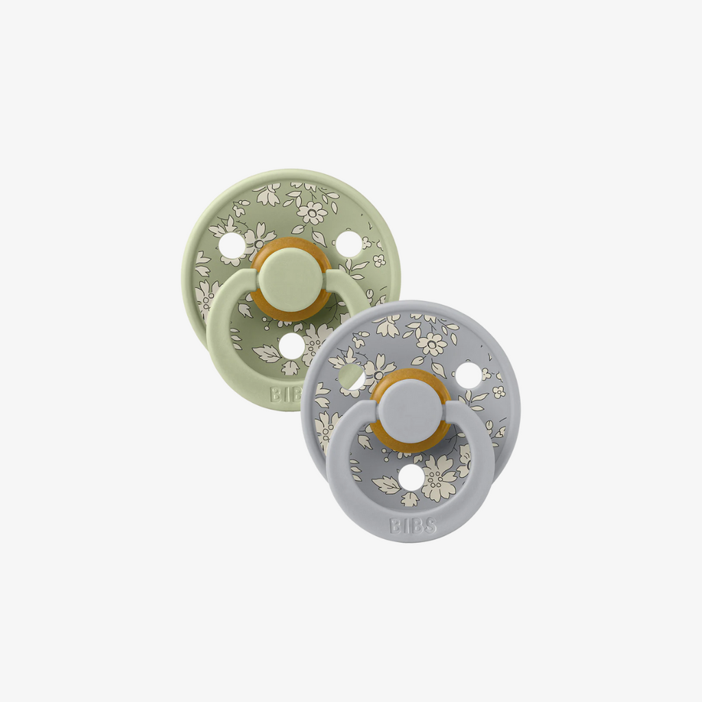 Two baby pacifiers with floral patterns on a white background