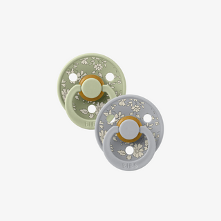 Two baby pacifiers with floral patterns on a white background