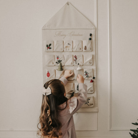 Christmas Advent Calendar with little girl facing calendar.