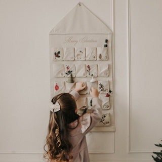 Christmas Advent Calendar with little girl facing calendar.