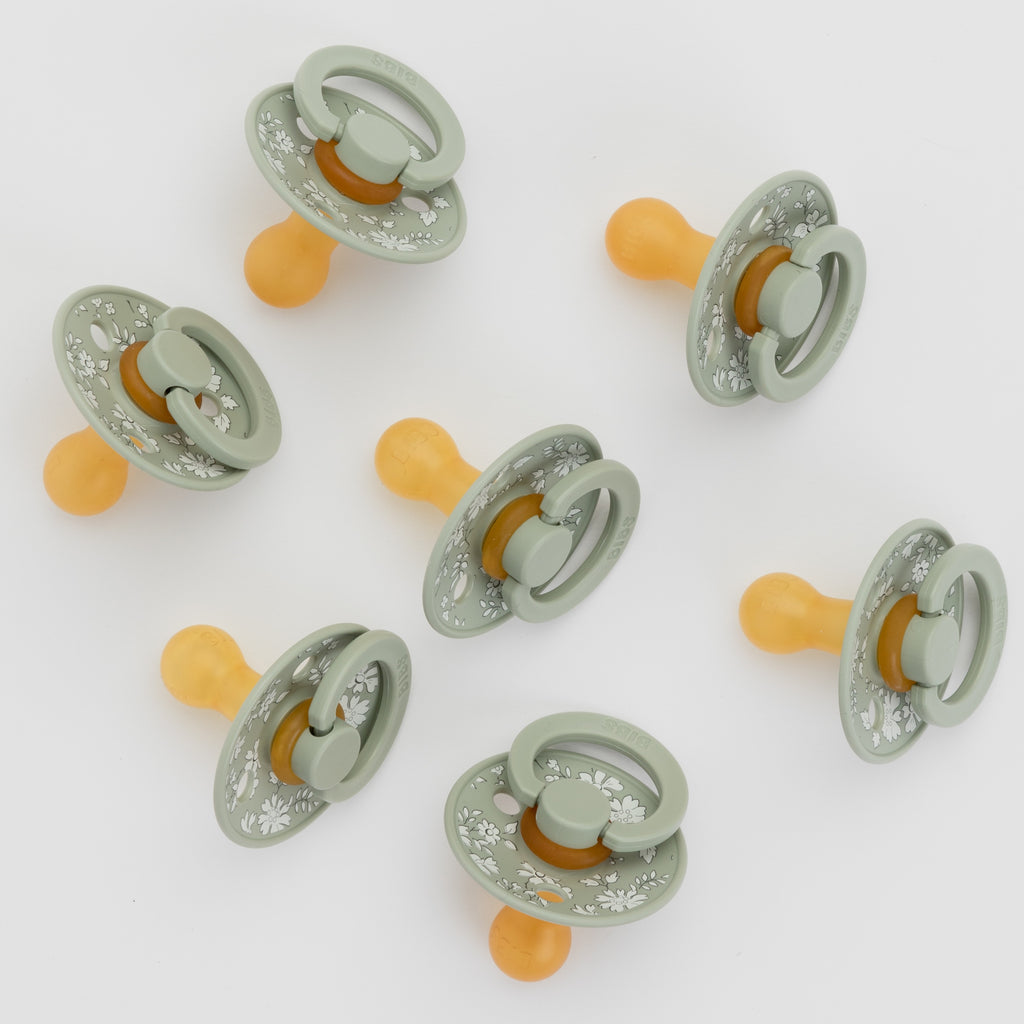 Set of baby pacifiers with GREEN and orange design on a white background
