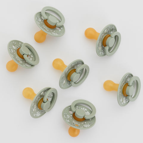 Set of baby pacifiers with GREEN and orange design on a white background