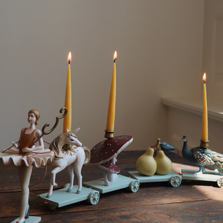 Decorative candle holders with candles on a wooden surface