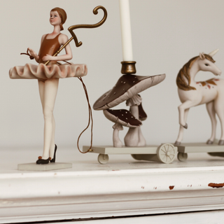 Decorative items including a ballerina figurine, mushroom, and unicorn on a shelf.