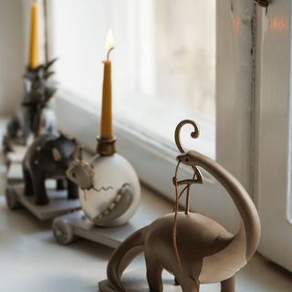 Decorative elephant figurine with a candle on a windowsill