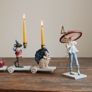 Decorative figurines with candles on a wooden surface