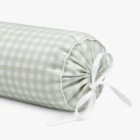 Green checkered cylindrical pillow with a white ribbon on a white background
