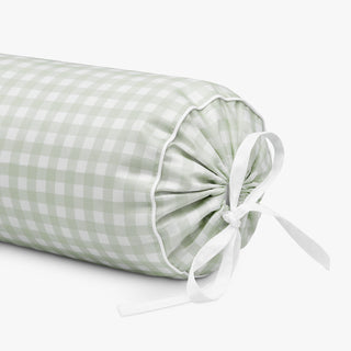 Green checkered cylindrical pillow with a white ribbon on a white background