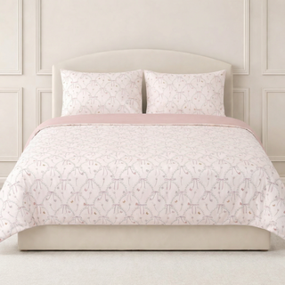 Floral butterly patterned duvet set on a bed with matching pillows against a neutral wall.