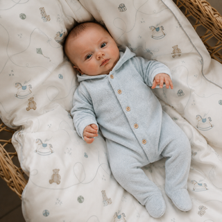 Baby laying ontop of duvet in a polar fleece suit