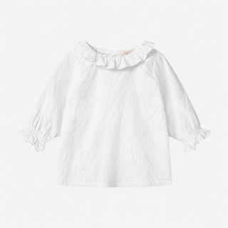 A white long-sleeve blouse for babies, featuring a ruffled collar and ruffled cuffs, displayed against a light gray background.