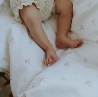 Baby legs and feet on a floral bedspread