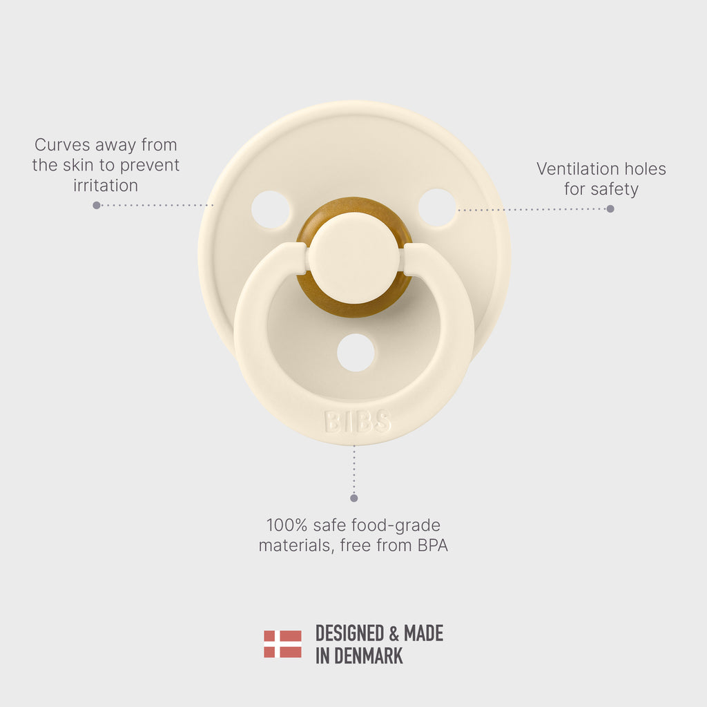 Cream-colored pacifier with text highlighting features on a light gray background