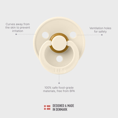 Cream-colored pacifier with text highlighting features on a light gray background