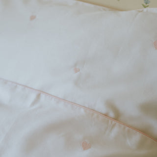 Close-up of a light pink fabric with heart patterns