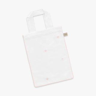 White tote bag with pink heart patterns on a white background