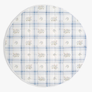 Round placemat with blue plaid pattern and floral designs on a white background