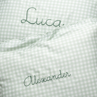 Text 'Luca' and 'Alexander' embroidered on a checkered green pillow.