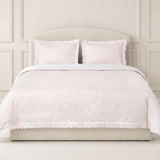 Pink gingham full queen bedding with two pillowcases on a beige bed