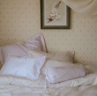 Bed with checkered pillows and a framed picture on the wall