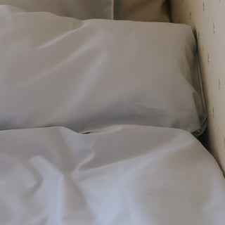 Close-up of blue duvet on a bed with a neutral background